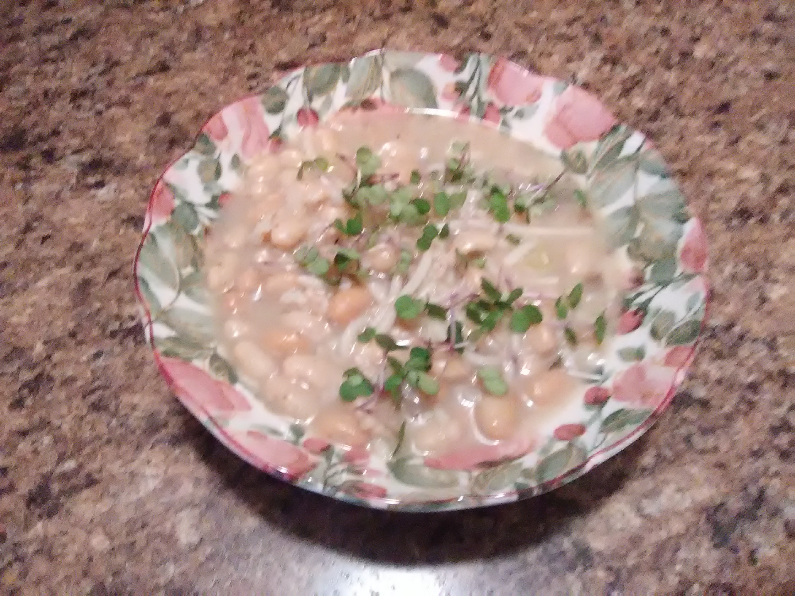 Bowl of homemade soup garnished with fresh microgreens for added color and nutrition