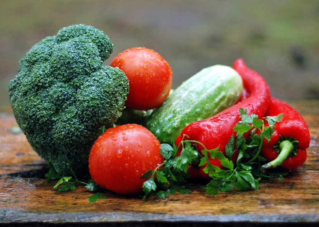 Vibrant fall harvest featuring peppers, broccoli, and tomatoes in October in the Heirloom Garden.